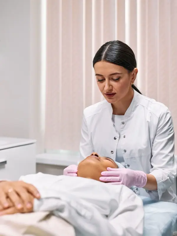 A cosmetologist performing a facial treatment for a client