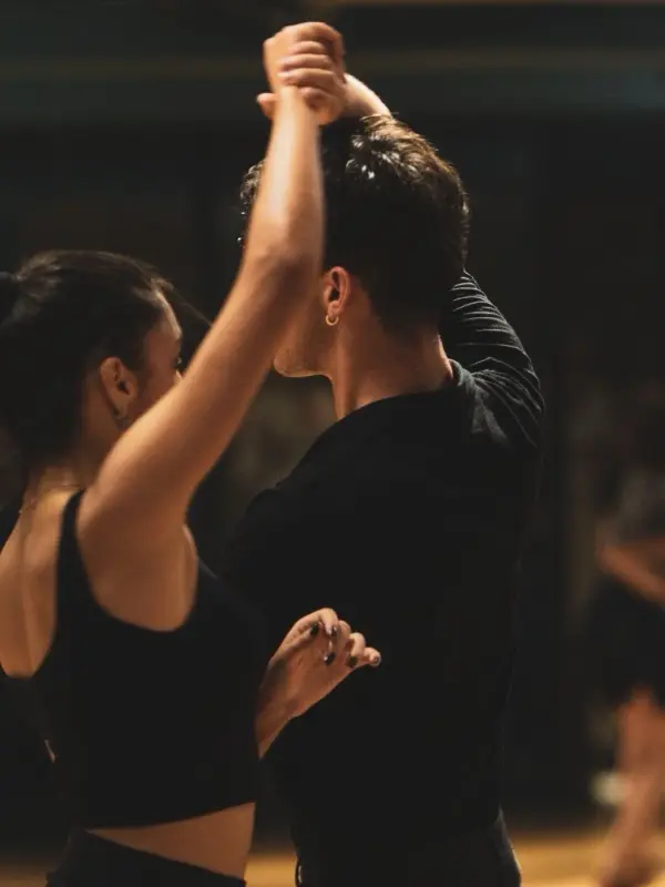 A couple rehearsing a dance in a mirrored studio