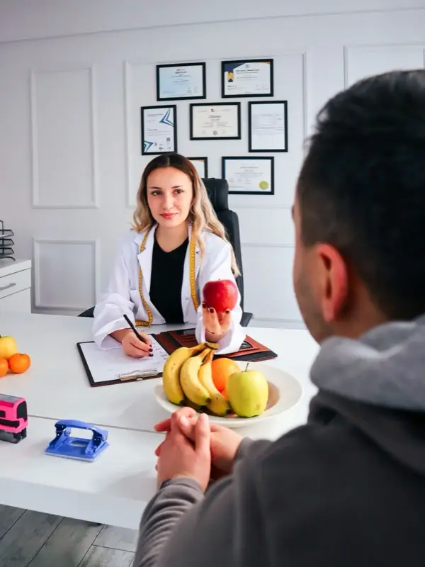 A nutritionist consulting a client at the desk