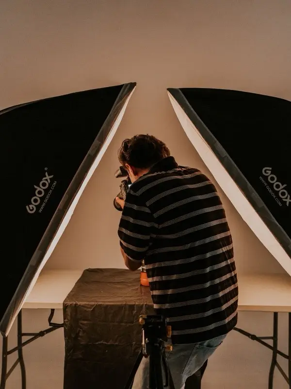 A photographer at work between two softboxes in the studio