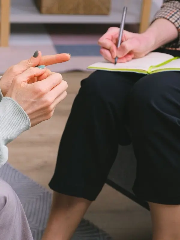 A therapist taking notes during a session with a client